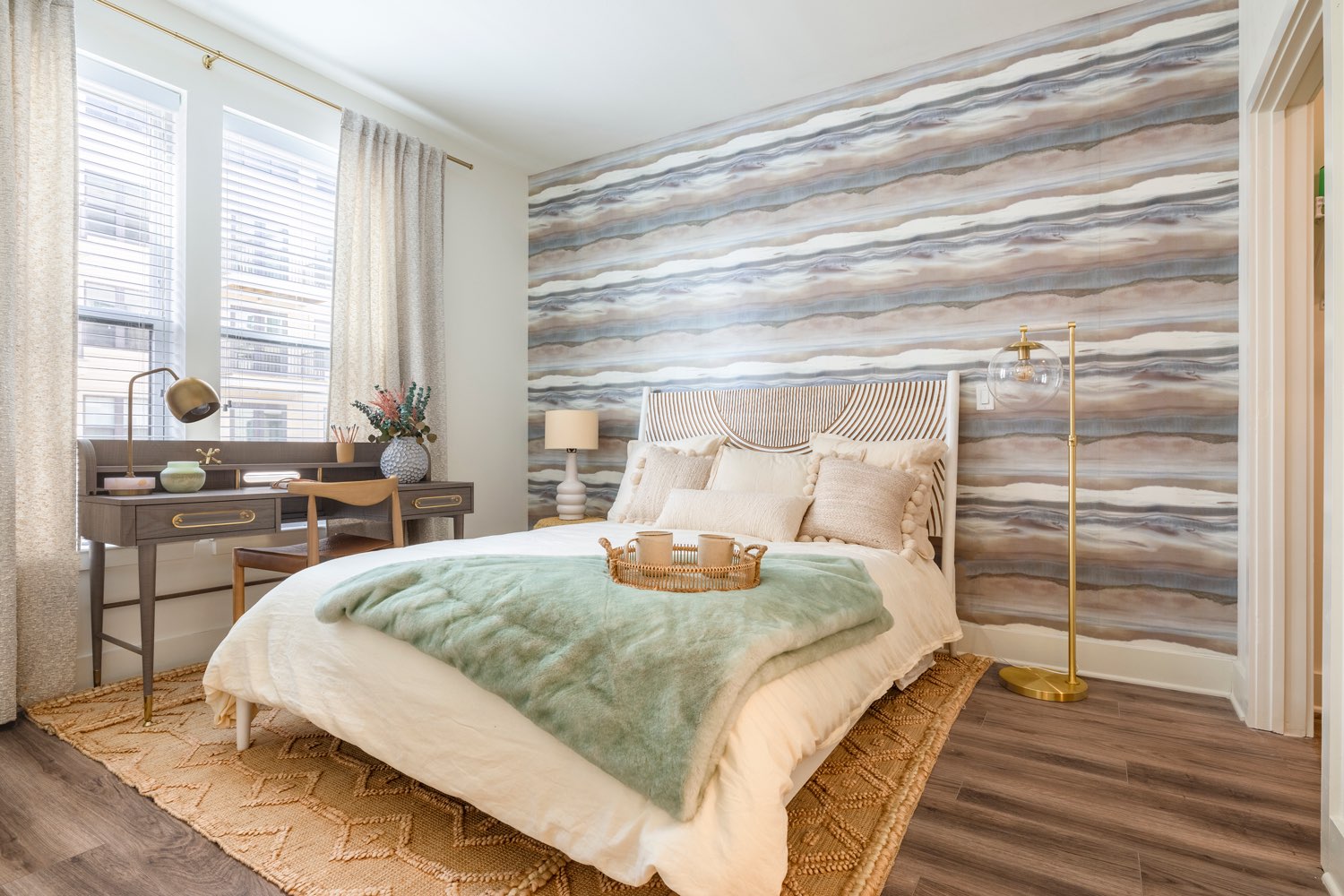 A bedroom with an abstract wallpapered wall.