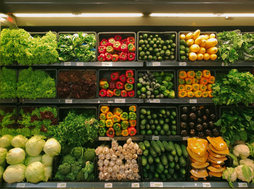 Vegetables in bins in grocery store refrigerator.