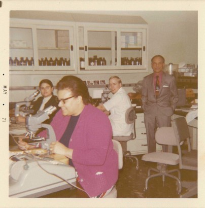 An antique photo of of a lab. Various people do work.