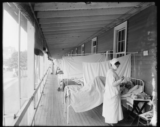 Black and white image of a woman working at a hospital.